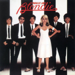 Debbie Harry in a white dress with hands on hips, flanked by men in suits, on Blondie's Parallel Lines album cover.