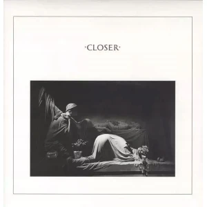 Monochrome artwork showing a figure lying on a bed with another person seated nearby and flowers nearby.