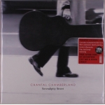 Album cover: a person walks with a large guitar case in black-and-white, red sticker with track titles visible; ‘Chantal Chamberland’ ‘Serendipity Street’ label at bottom.
