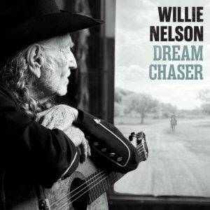 Side-profile of an elderly man with a cowboy hat and guitar, gazing out a window; poster to the right reads 'WILLIE NELSON DREAM CHASER'.