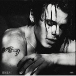 Black-and-white portrait of a shirtless person with wet hair, arm resting, tattoo reads 'Don’t Forget to Live' and album label 'IDOLS II' in corner